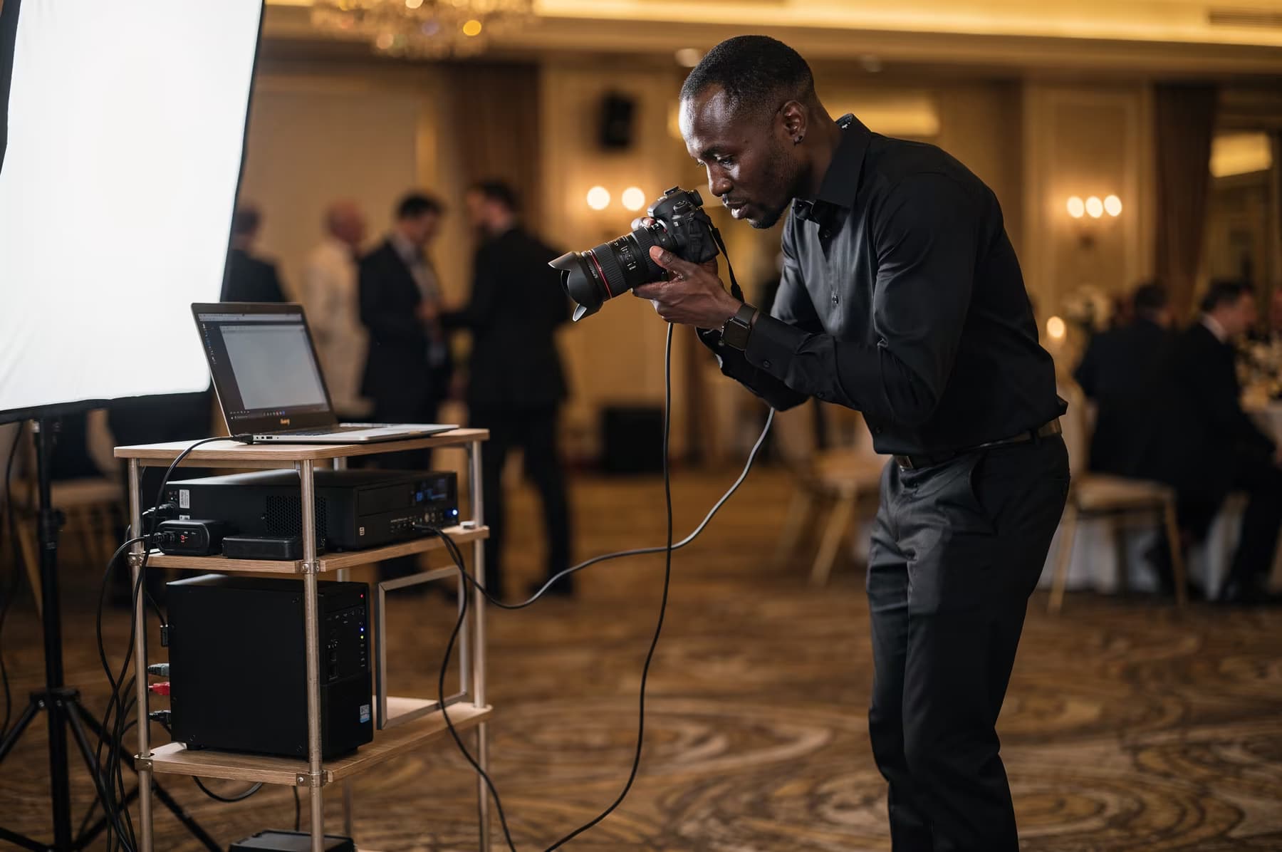 Un photographe utilise un appareil relié à son installation pendant un événement